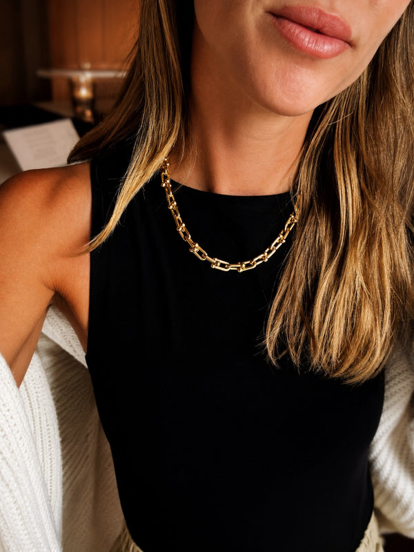 Ambitionist High Neck Tank in black styled with gold chain and cream knit